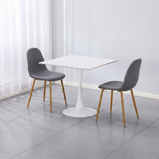 Two gray velvet chairs on a white ceramic coated table on a lifestyle background